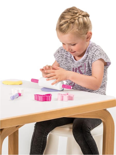 Lyslilla skål med piskeris og lyserøde bageforme samt hvidt og lyserødt køkkenudstyr til legebrug