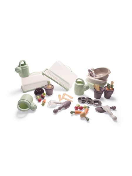 To børn ved et udemøbel, der arbejder med plante- og havesæt med grønne redskaber og små potter