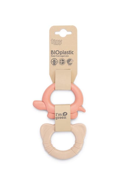 Rosa og beige bideringe til baby, sammenkoblet på brun emballage.