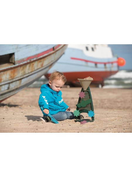 To små figurer på strand ved båd - en i blå dragt og en i grøn dragt leger i sandet