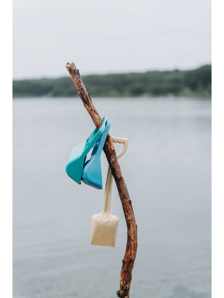 To lysegrønne og turkise sandgrabber med håndtag og tænder til sandkasseleg.