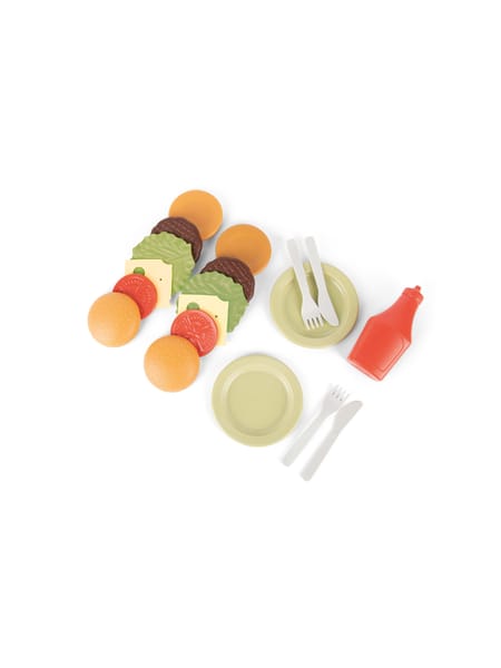 Person ved udendørs køkkenvask i orange kjole leger med legetøj