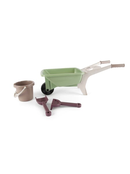 En børnetrillebør i lyserød placeret på træterrasse med grønne træer i baggrunden.