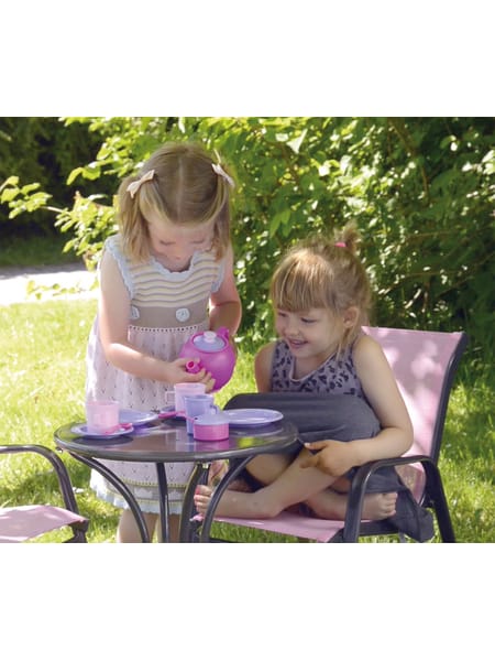 Børn ved bord med lyslilla og lyserøde kopper og tallerkener til teselskab