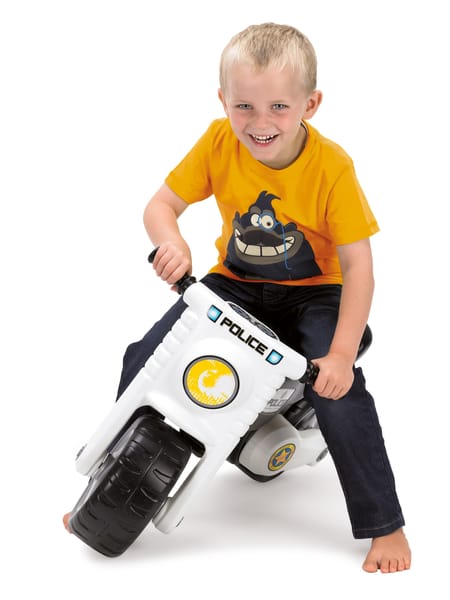 Barn på hvid motorcykel i legetøjsstørrelse. Motorcyklen er hvid med sort sæde.