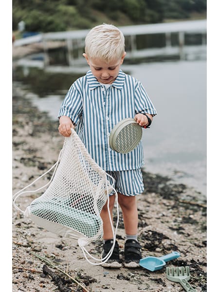 Strandsæt med grøn spand, turkis båd, blå skovl og beige rive til sandkasse og strand