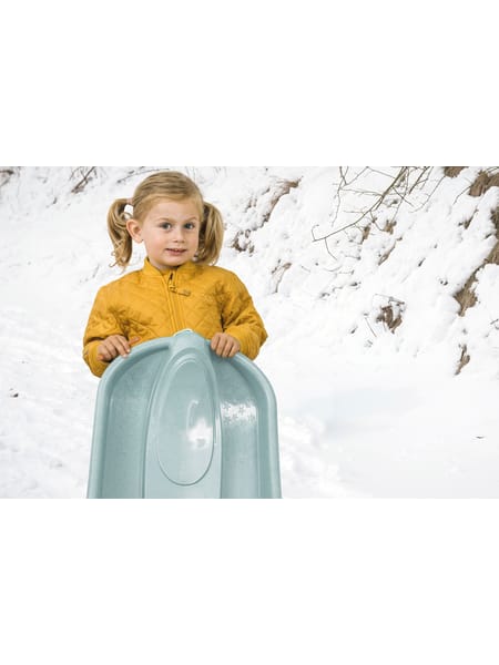 Barn i gul trøje placeret på stor lysegrøn beholder i stiliseret fotomanipulation.