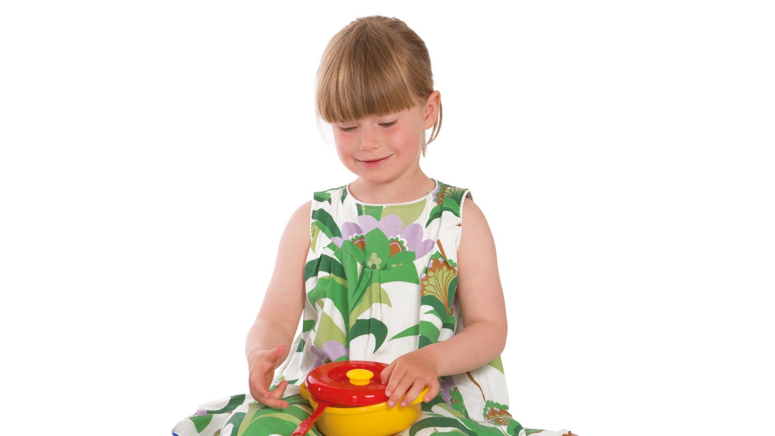 Barn i blomstret kjole leger med gul og rød legetøjsgryde.