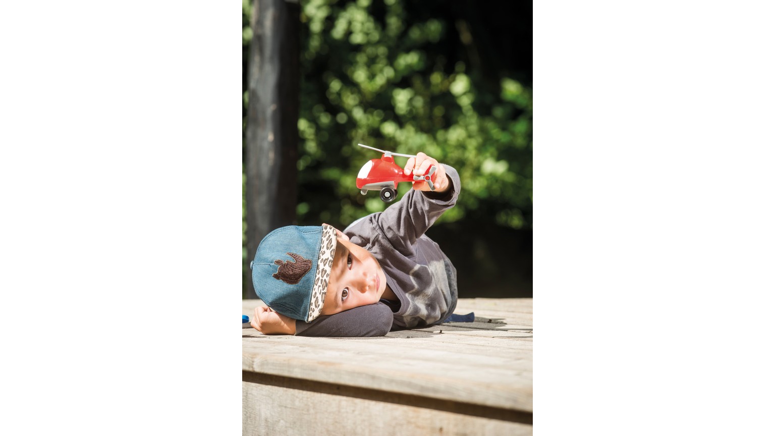 Person ligger på siden og holder rød genstand mod lys med grøn baggrund