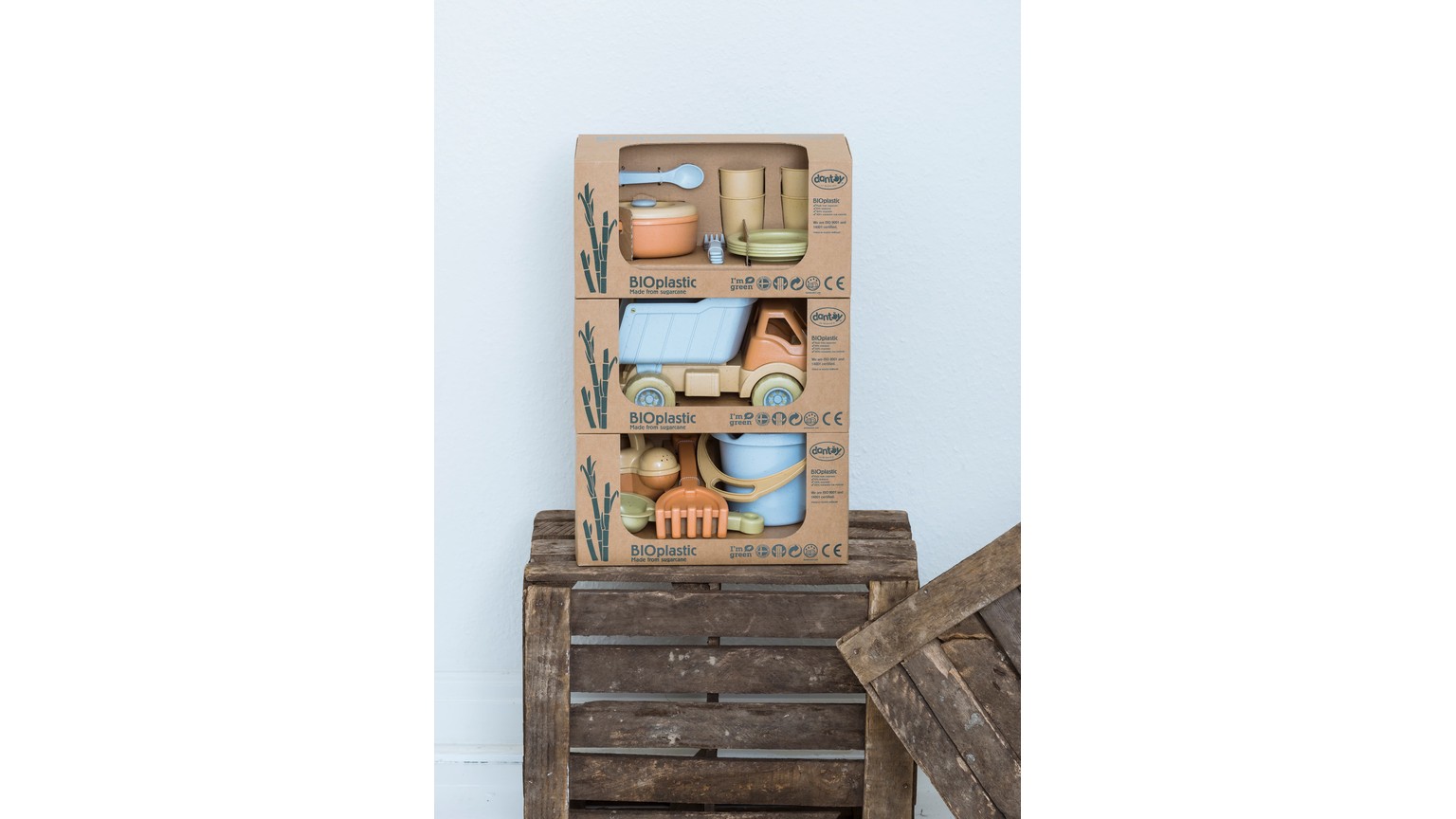 Lyseblåt legetøjssæt med bil og tilbehør på rustik træbaggrund