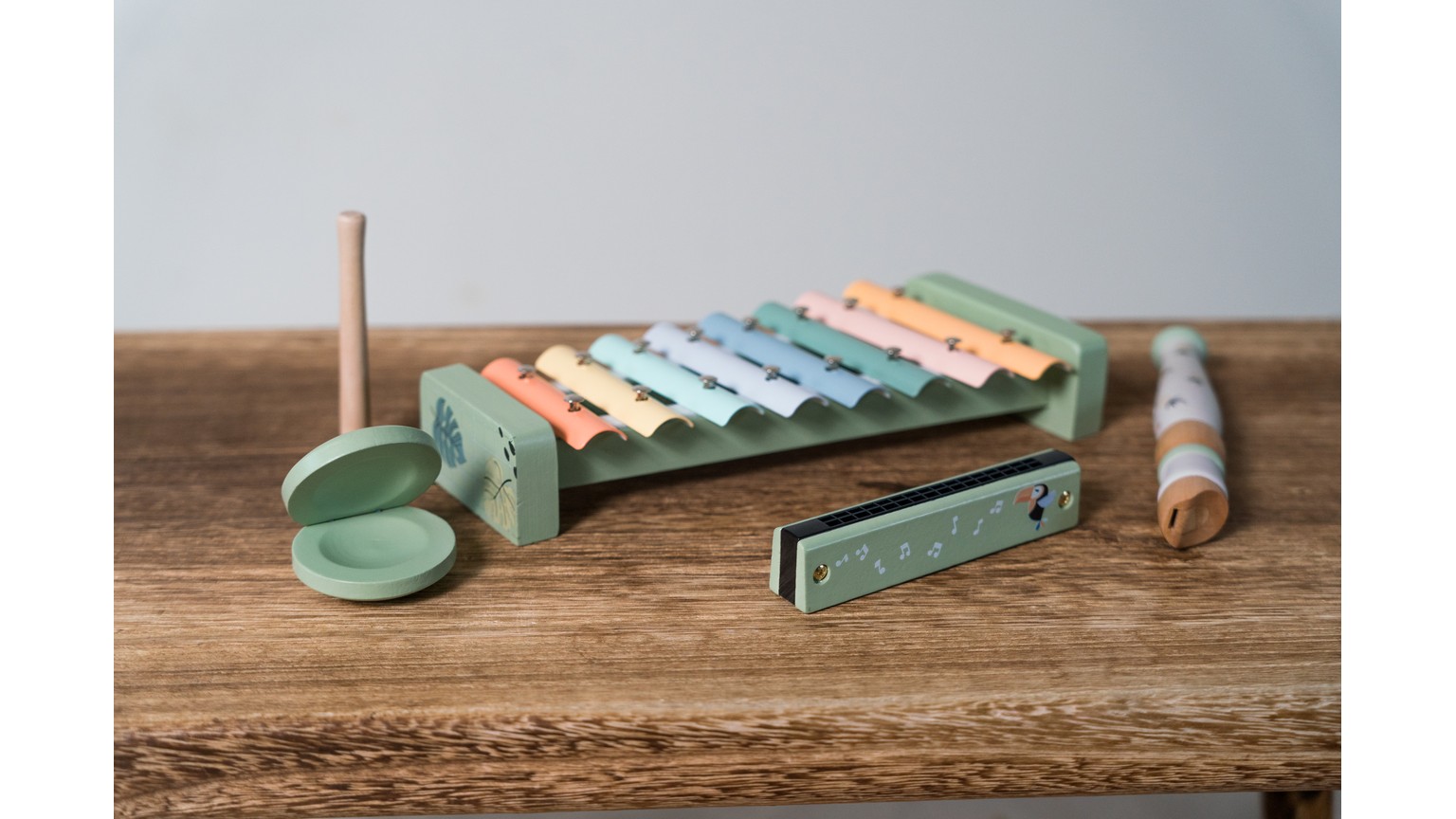 Grønt og farverigt børnexylofon med tilhørende musikinstrumenter på træbord
