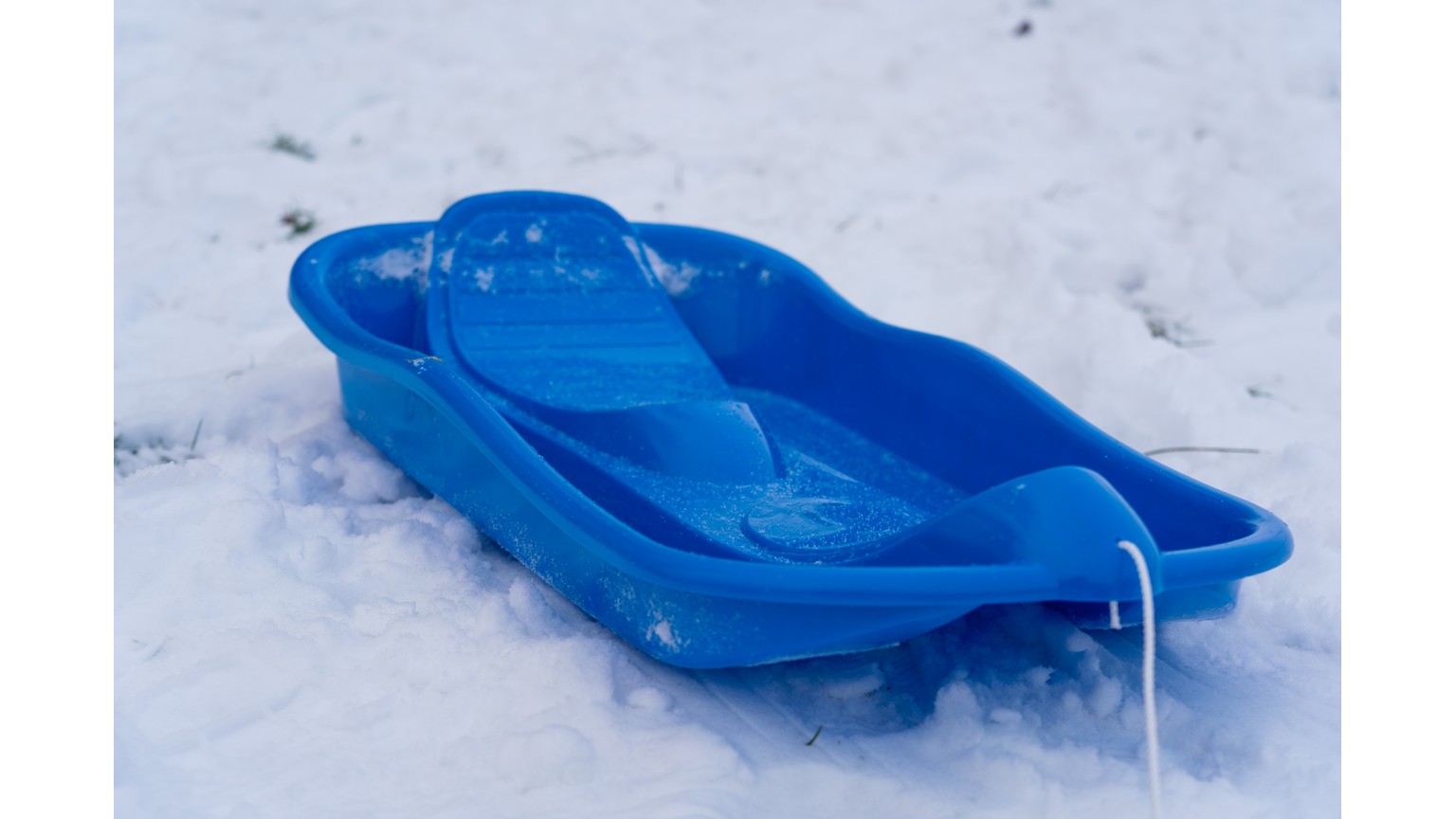 Blå kælk i sneen med rebsnor foran