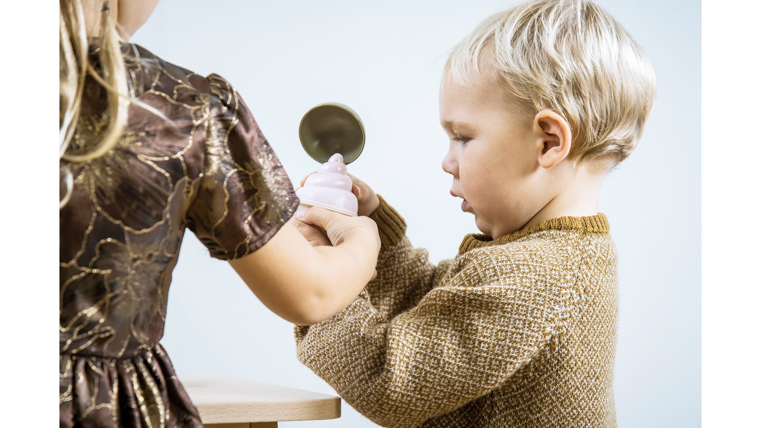 Barn og voksen med lægestetoskop under en legeundersøgelse.