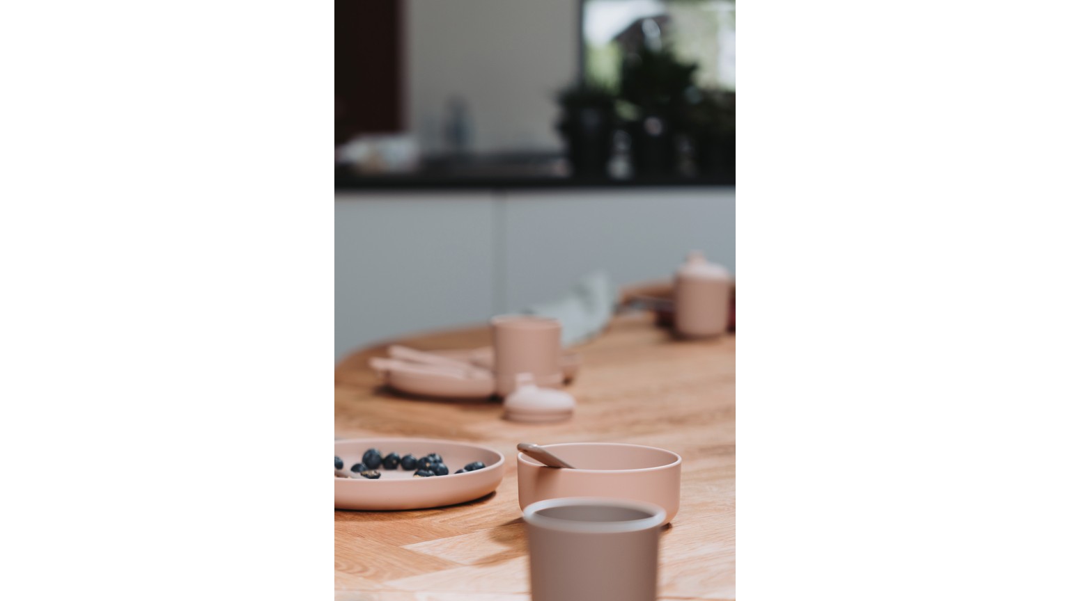 Grå kopper på træbord med en skål med blåbær ved siden af