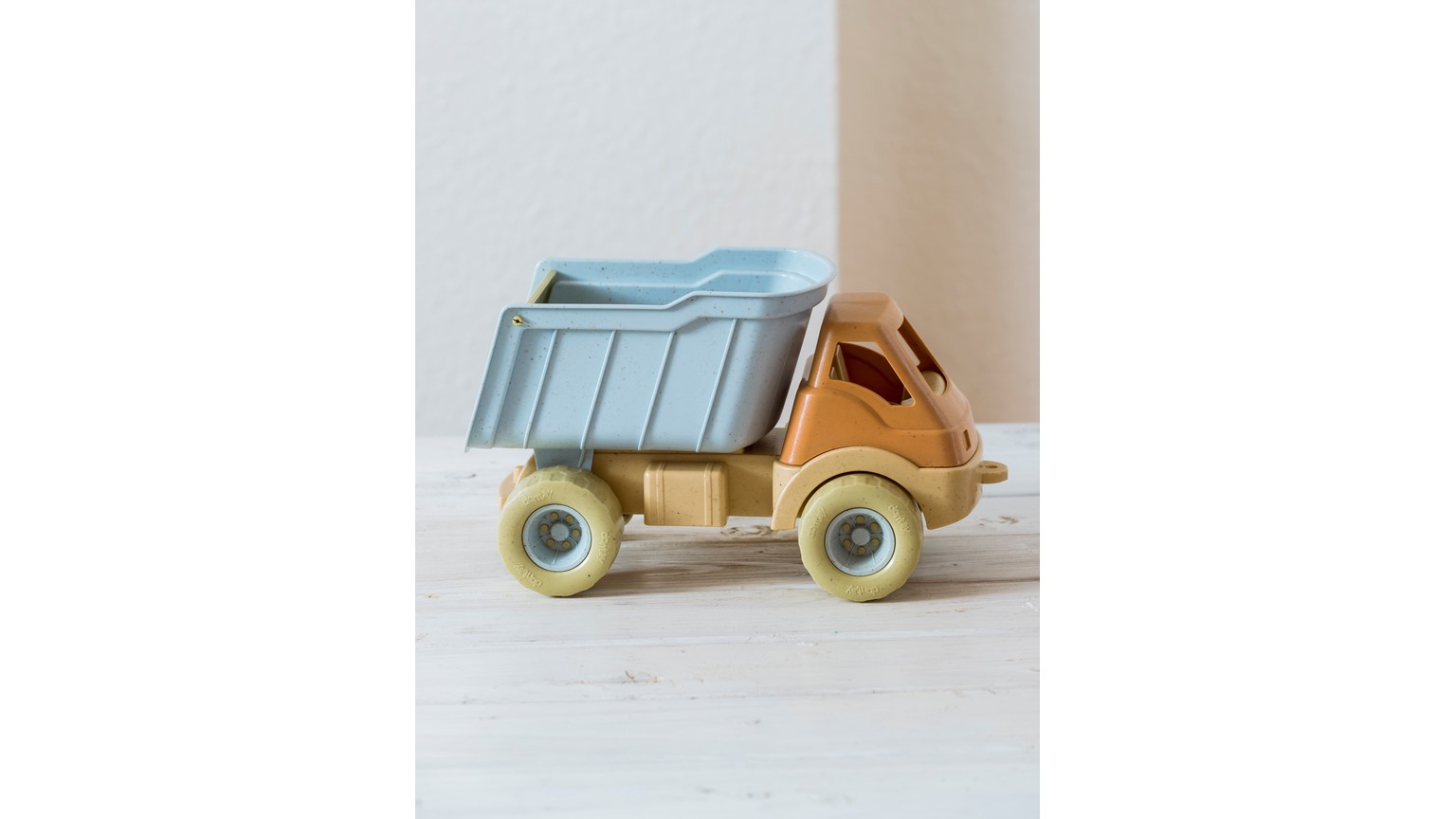 Blå og beige legelastbil med tippelad på hvidt underlag