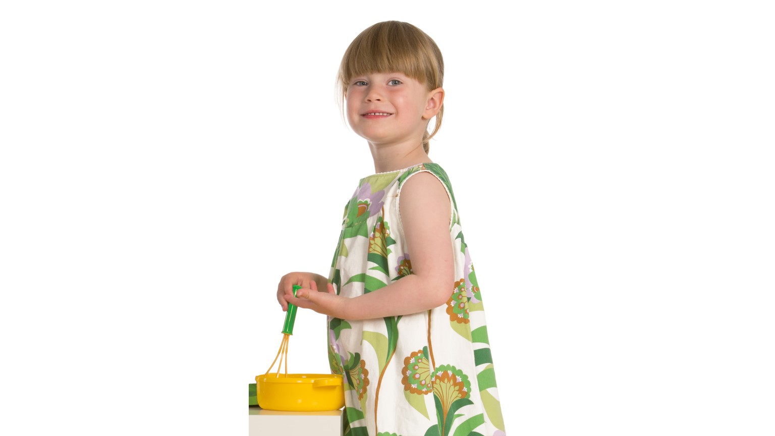 Person i blomstret kjole holder gul plastik køkkentaske fra legesæt